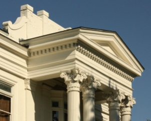 The Queen Anne brick parapet behind the portico is larger than Woodside's Greek Revival parapet.